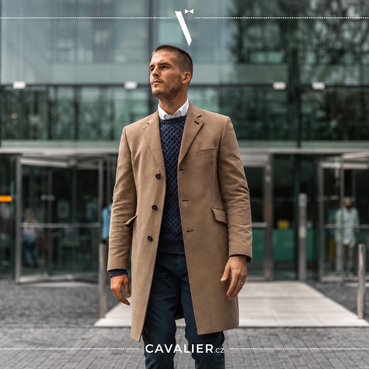 Muž ve velbloudím kabátu na míru a svetru v elegantním smart casual stylu.