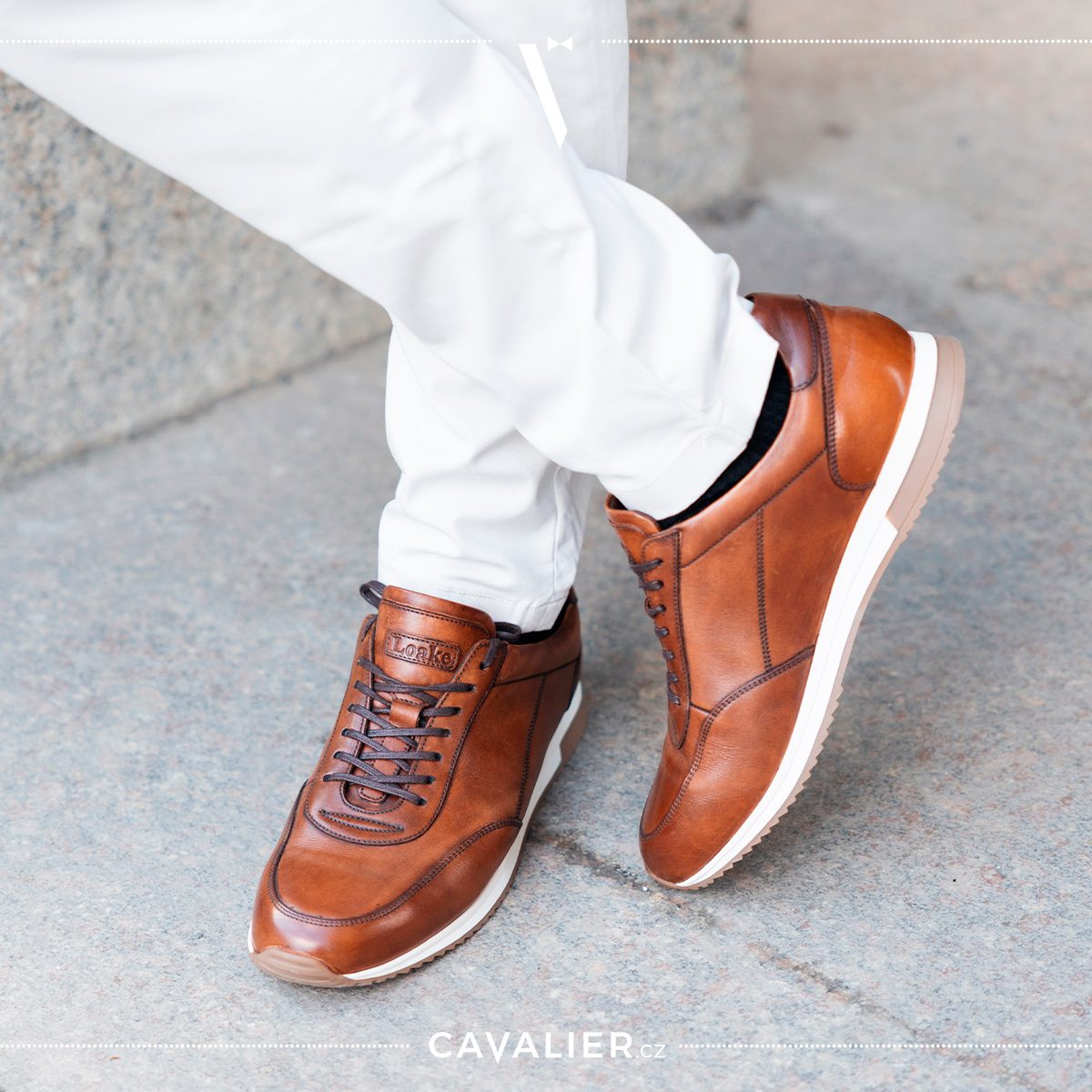 Detail elegantních hnědých kožených tenisek Loake v kombinaci se světlými kalhotami na míru – ideální volba obuvi pro moderní pánský smart casual styl.